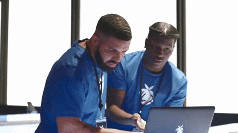 [Redacted] and Lil Yatchy in blue shirts looking at a laptop.